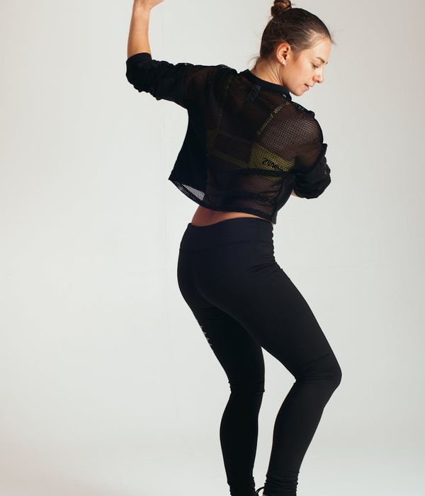 Athletic woman performing dynamic movements in a dark studio